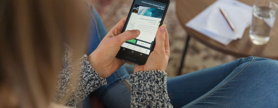 Vrouw op de bank met telefoon in haar handen